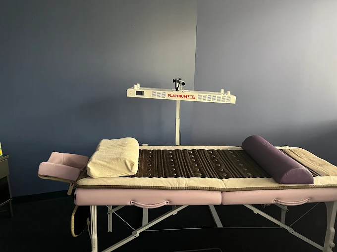 Current Google profile photo: an unoccupied treatment table with bolsters and an infrared lamp